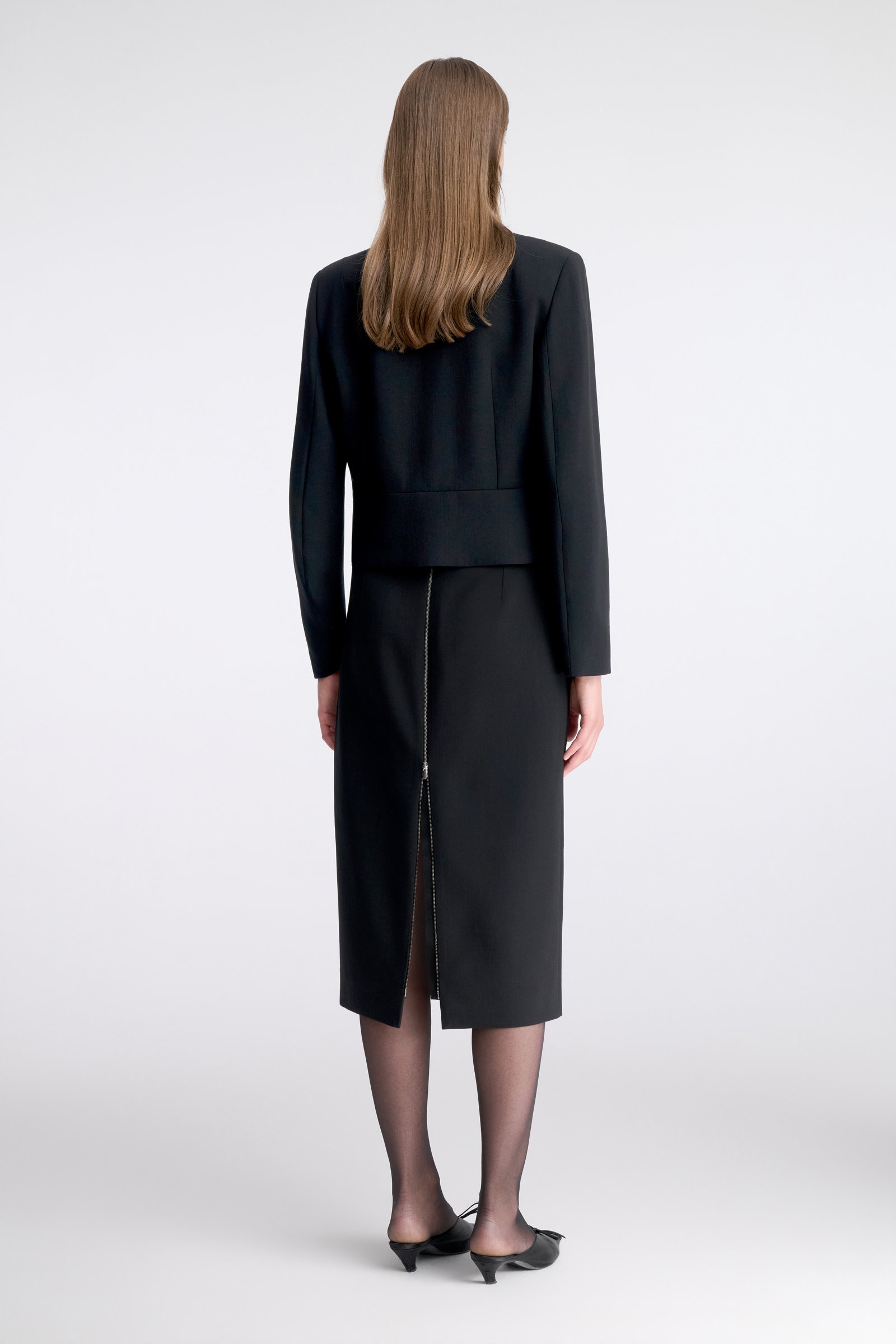 1084/B6 A black, short wool jacket with a zip fastening